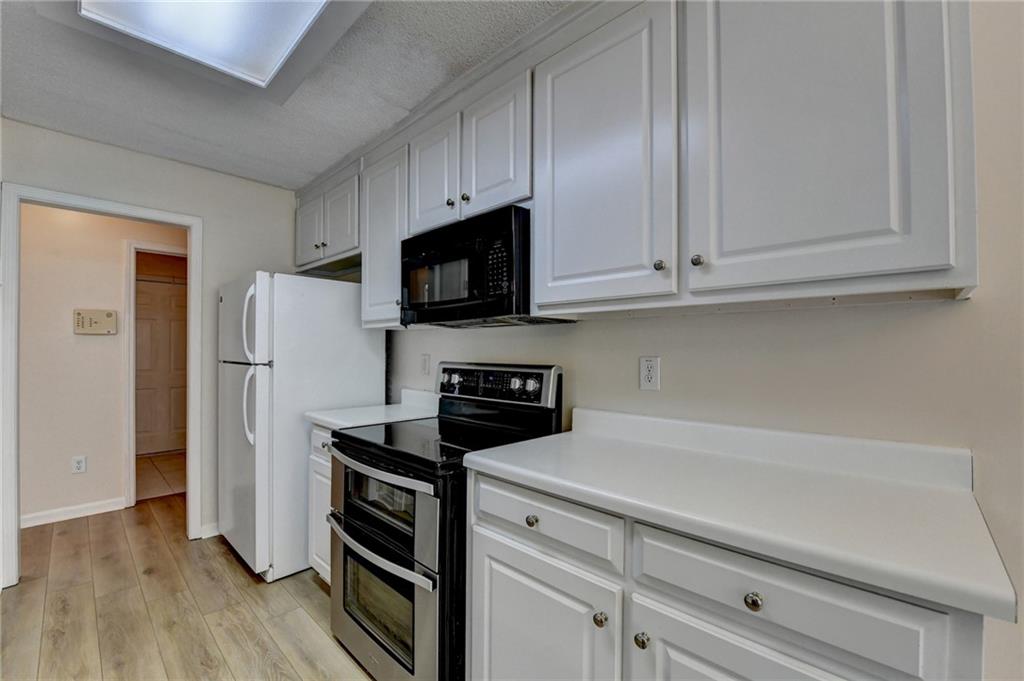 601 Bowling Lane Winder, GA 30680 - Photo 20 of 45 a kitchen with cabinets stainless steel appliances and wooden floor