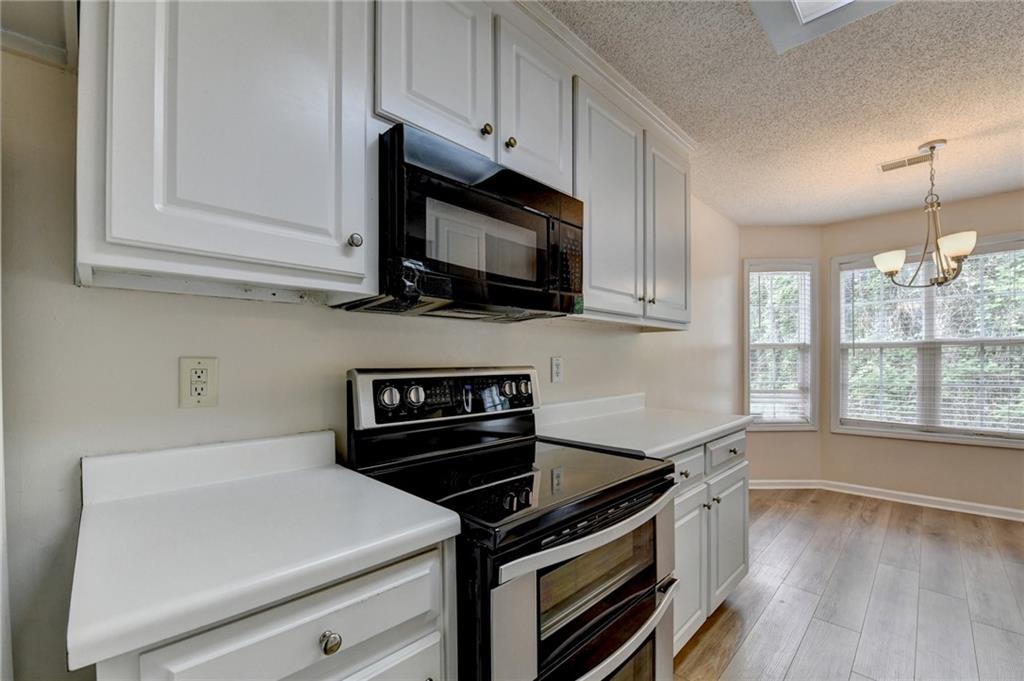 601 Bowling Lane Winder, GA 30680 - Photo 22 of 45 a kitchen with stainless steel appliances a stove a microwave and cabinets