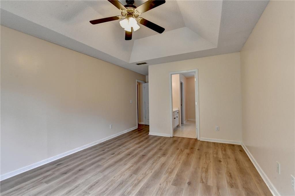 601 Bowling Lane Winder, GA 30680 - Photo 27 of 45 an empty room with wooden floor and a ceiling fan
