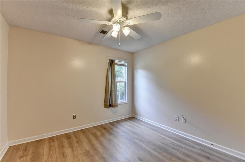 601 Bowling Lane Winder, GA 30680 - Photo 38 of 45 an empty room with a chandelier fan and windows