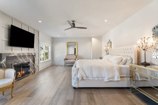 a spacious bedroom with a bed and a flat screen tv