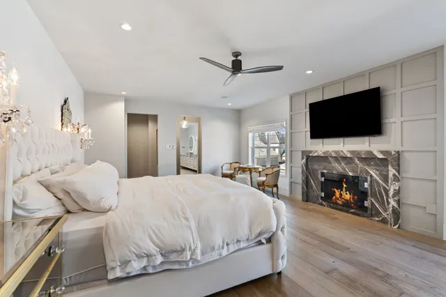 a spacious bedroom with a bed and a flat screen tv