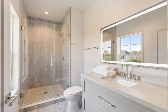 a bathroom with a sink a toilet and shower