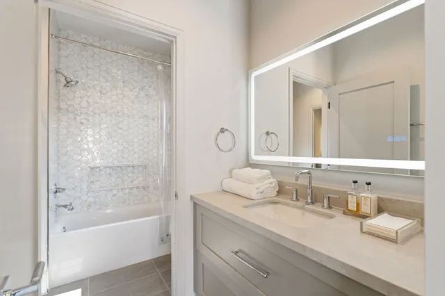 a bathroom with a granite countertop sink mirror and a bathtub