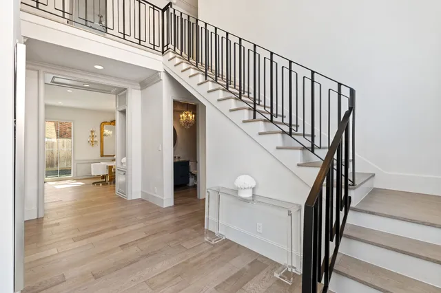 a view of a hallway with wooden floor and stairs