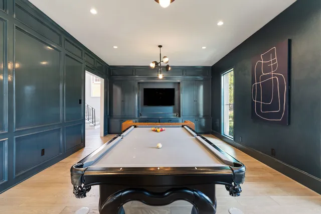 a room with pool table and windows