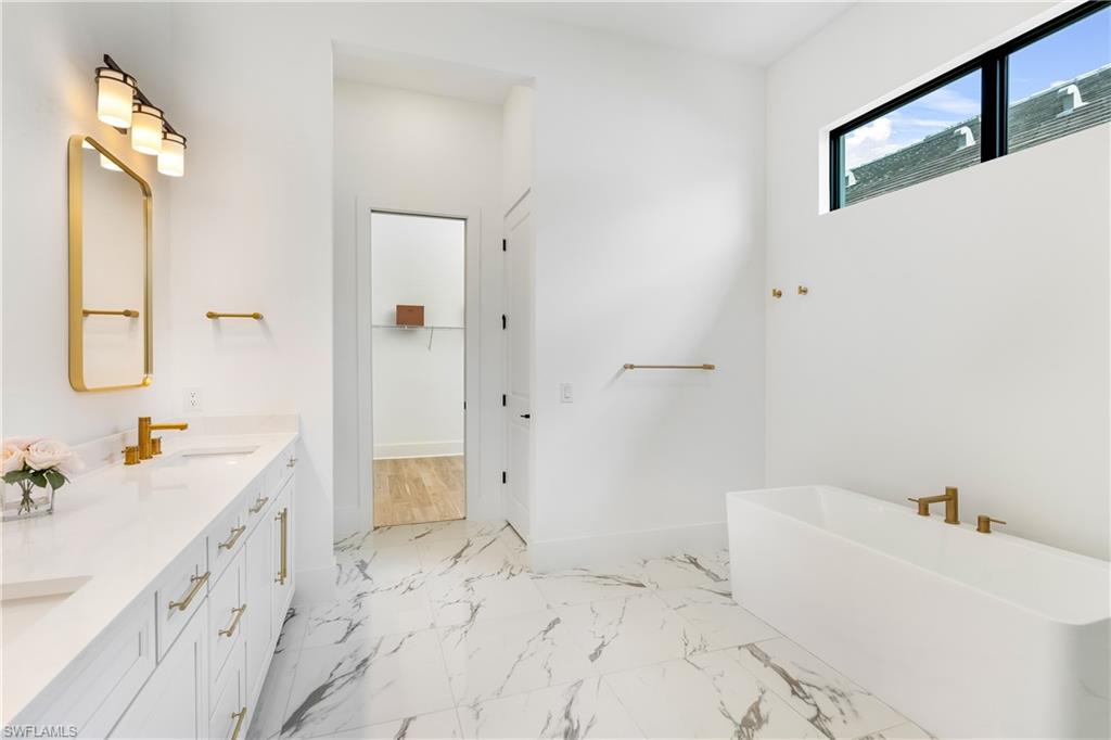 9560 Caymas Terrace Naples, FL 34114 - Photo 15 of 40 a bathroom with a tub sink and mirror