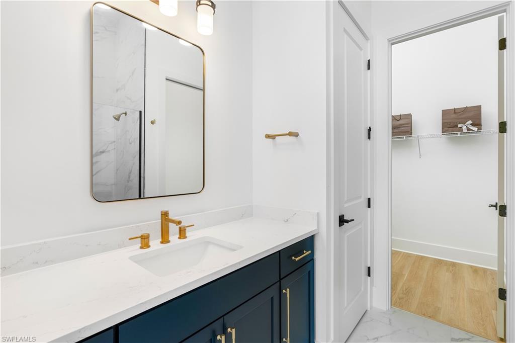 9560 Caymas Terrace Naples, FL 34114 - Photo 18 of 40 a bathroom with a sink vanity and a mirror