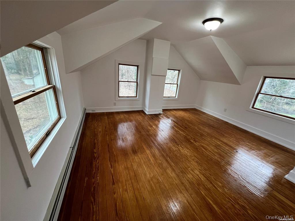 493 Munsell Road East Patchogue, NY 11772 - Photo 4 of 14 a view of an empty room with wooden floor and a window