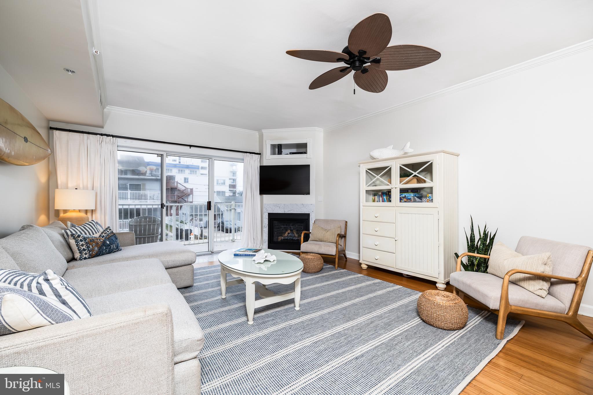 a living room with furniture a fireplace and a floor to ceiling window