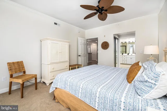 a bedroom with a bed ceiling fan and a wooden floor