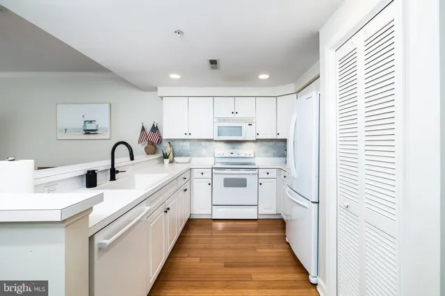a kitchen with white cabinets appliances and a sink
