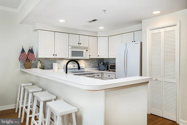 a kitchen with stainless steel appliances granite countertop a sink a stove a refrigerator and cabinets