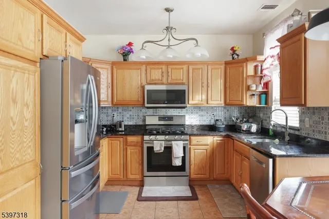 a kitchen with stainless steel appliances granite countertop a stove top oven a sink and dishwasher