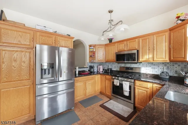 a kitchen with stainless steel appliances granite countertop a refrigerator a stove top oven a sink and dishwasher