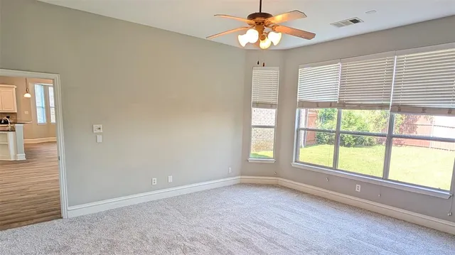a view of a hallway with wooden floor and a kitchen