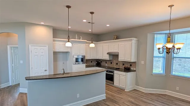a view of kitchen with refrigerator stove and wooden floor