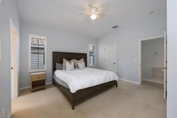 a spacious bedroom with a bed and a ceiling fan