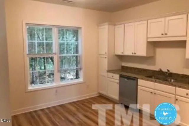 a kitchen with granite countertop a stove a sink and a window