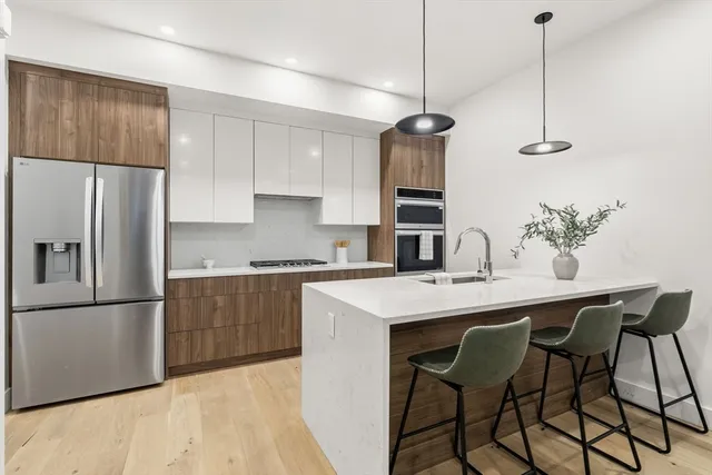 a kitchen with a sink a refrigerator a counter and cabinets