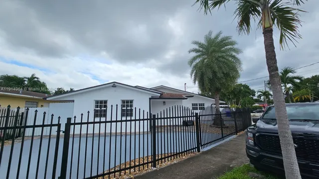a view of house with backyard and sitting area