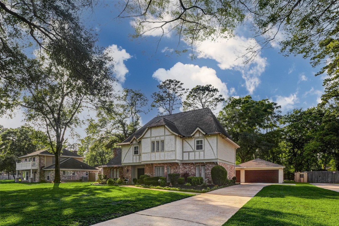 6710 Falling Waters Drive Spring, TX 77379 - Photo 2 of 45 A spacious driveway leads to a detached garage, and mature trees provide shade and privacy. The neighborhood appears serene and well-maintained, ideal for family living.