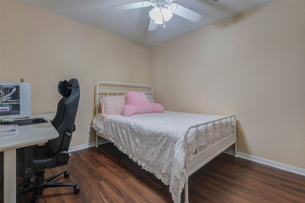 6710 Falling Waters Drive Spring, TX 77379 - Photo 30 of 45 This cozy bedroom features a ceiling fan, a walk-in closet, and a hardwood floor.