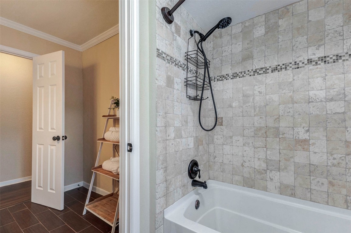 6710 Falling Waters Drive Spring, TX 77379 - Photo 32 of 45 2nd full bathroom features a tiled shower with a mosaic accent, a sleek black showerhead, and a white bathtub, with dark, modern tile flooring.