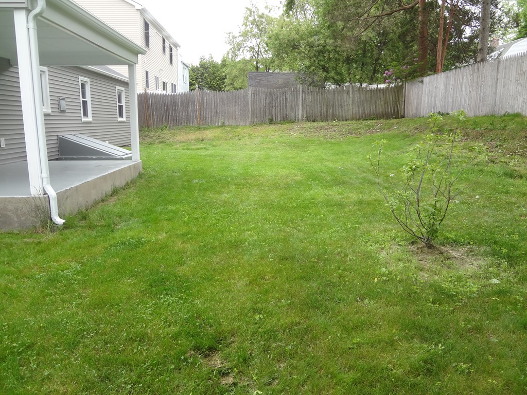 27 Bennington Street Springfield, MA 01108 - Photo 20 of 20 a view of a backyard with large trees and wooden fence