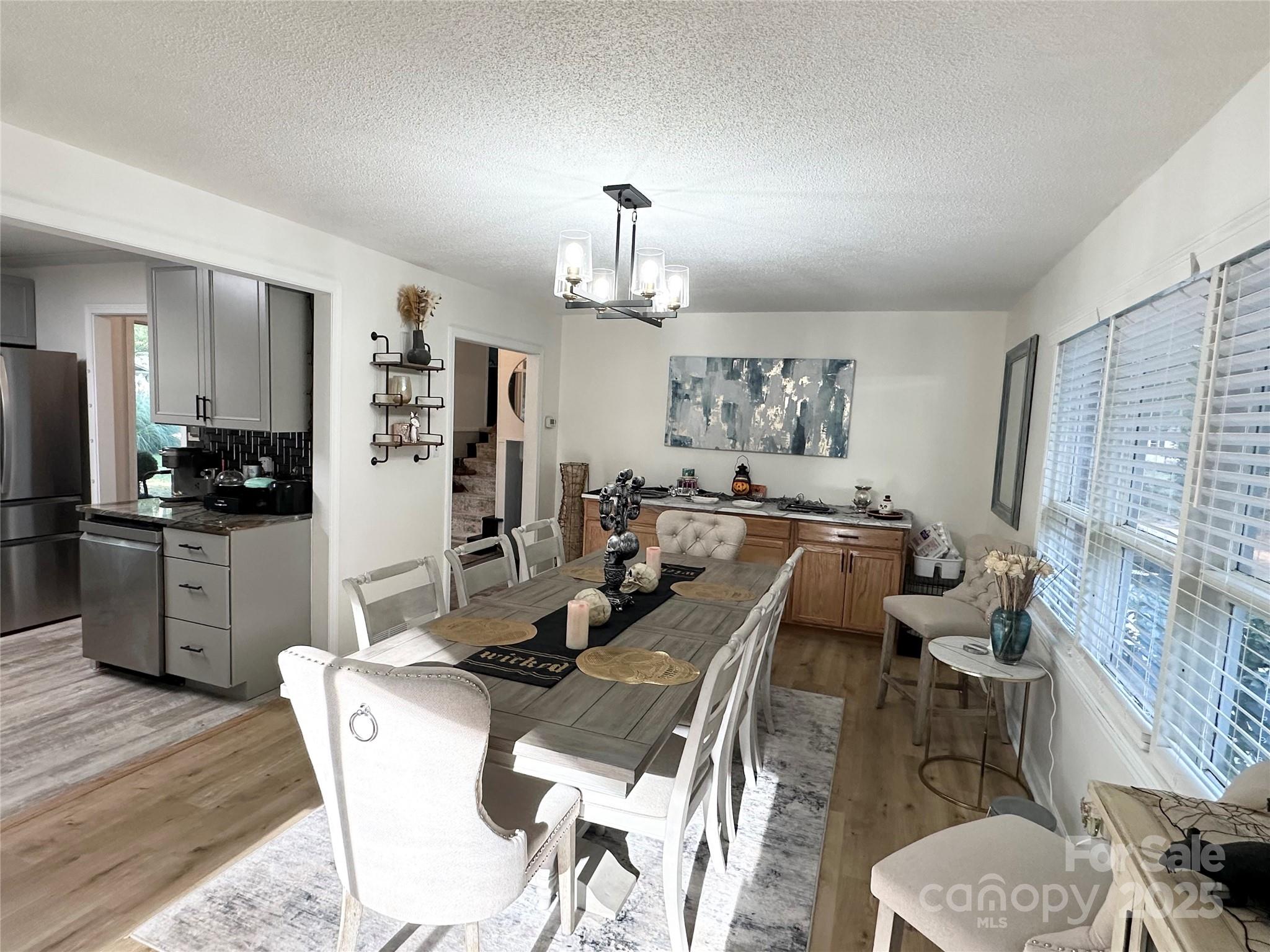 400 Charles Street Spencer, NC 28159 - Photo 11 of 26 a view of a dining room with furniture a kitchen and chandelier