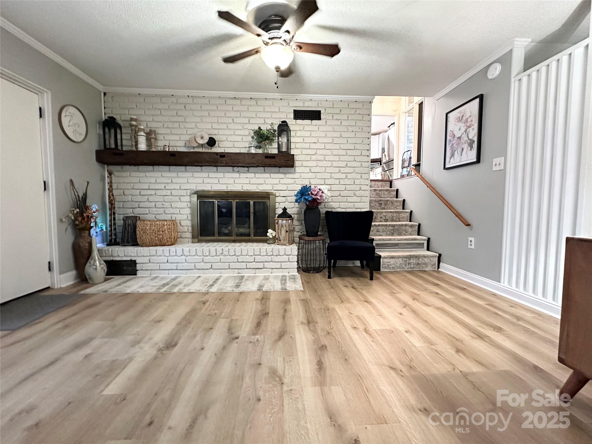 400 Charles Street Spencer, NC 28159 - Photo 12 of 26 a view of a livingroom with a fireplace a ceiling fan and windows