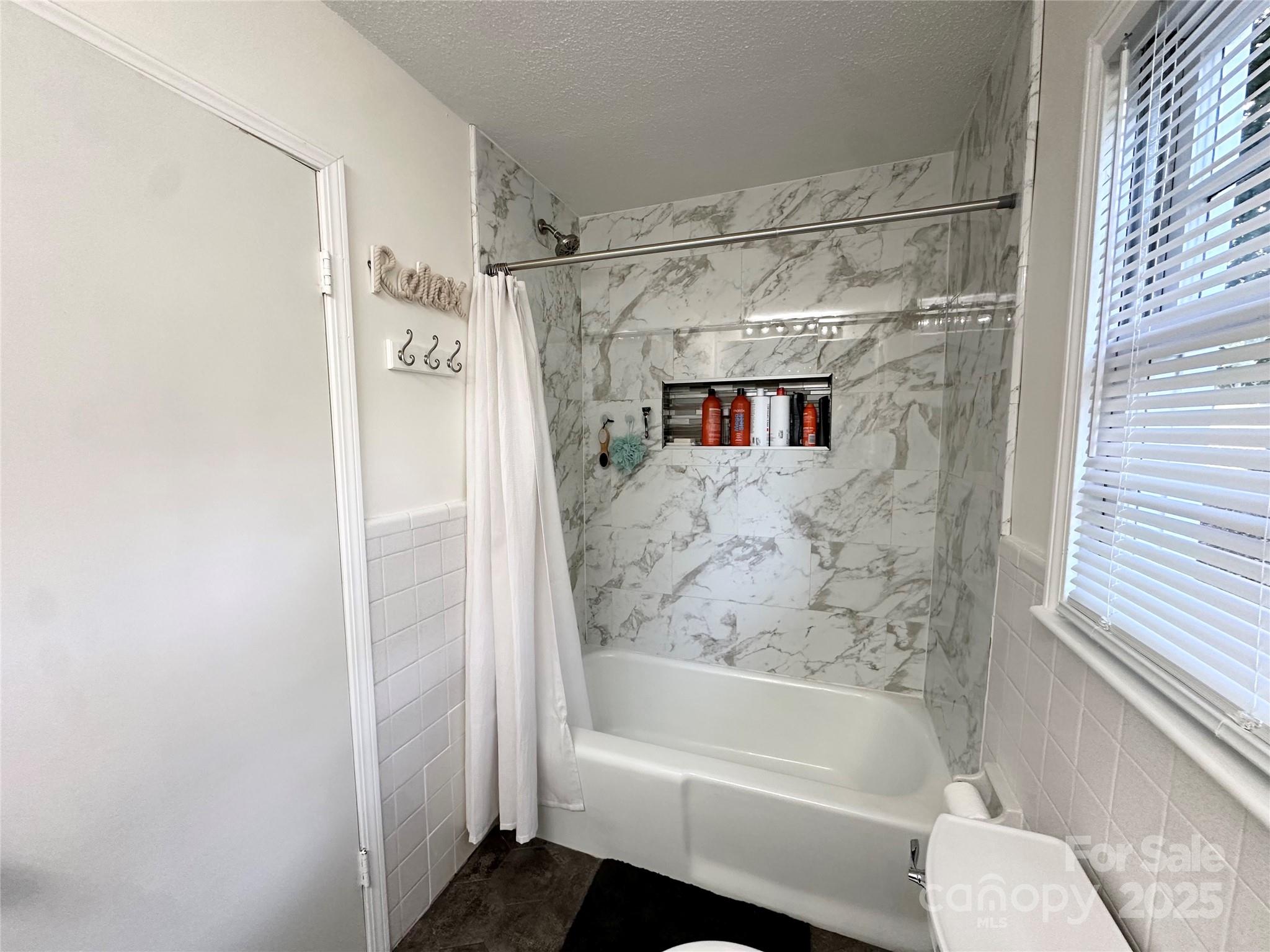 400 Charles Street Spencer, NC 28159 - Photo 21 of 26 a bathroom with a bathtub and a shower
