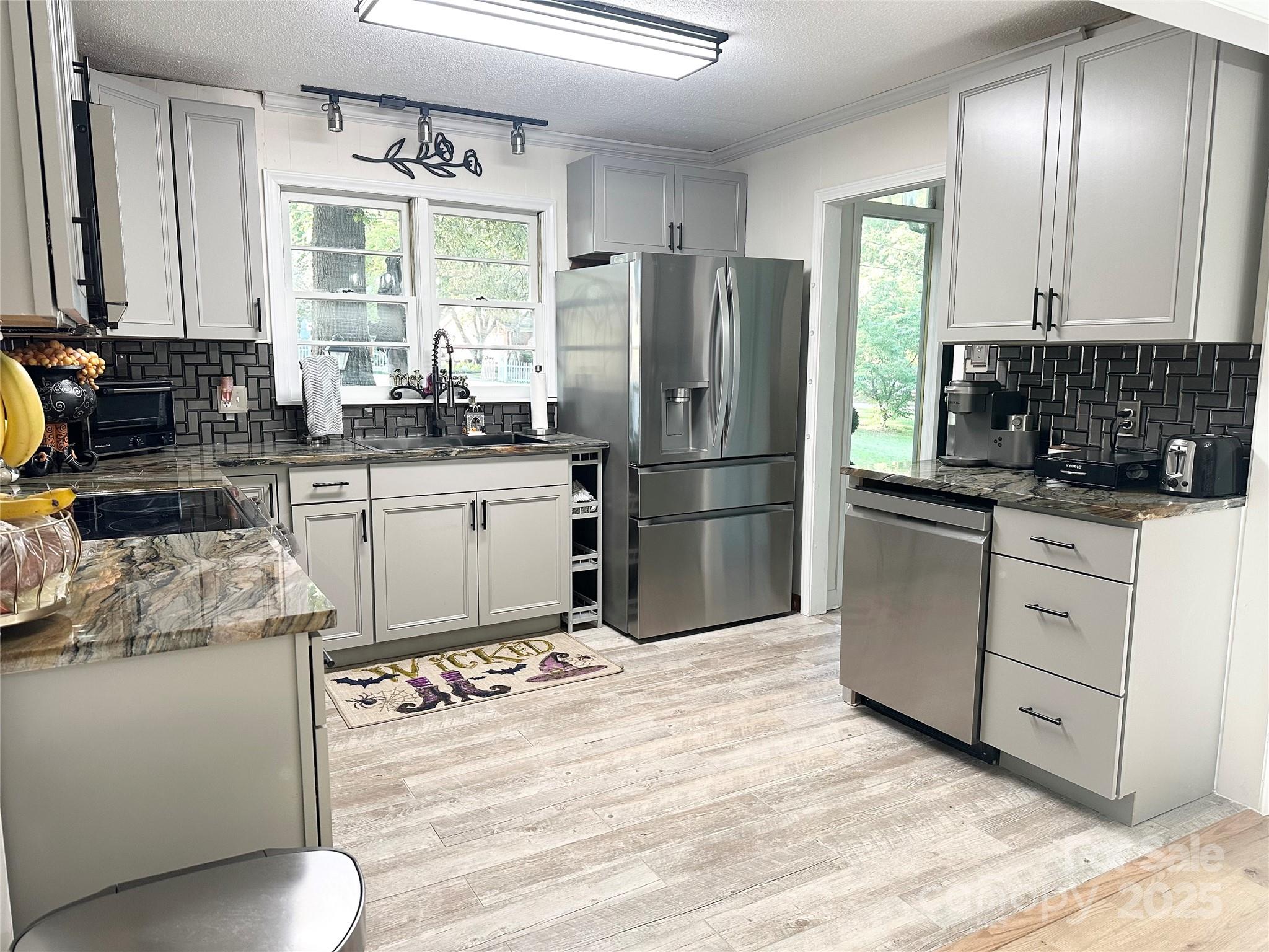 400 Charles Street Spencer, NC 28159 - Photo 8 of 26 a kitchen with granite countertop a refrigerator stove top oven and sink