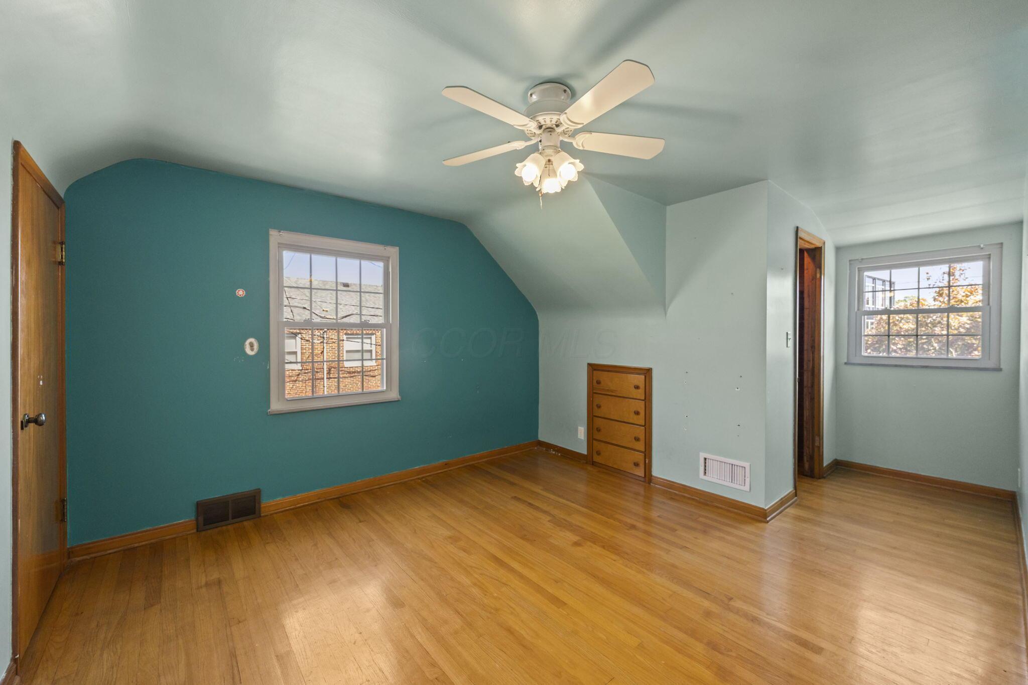 40 South Kellner Road Columbus, OH 43209 - Photo 26 of 57 Hardwood flooring throughout, featuring a built-in wood dresser, ceiling fan with light fixture, and two window openings
