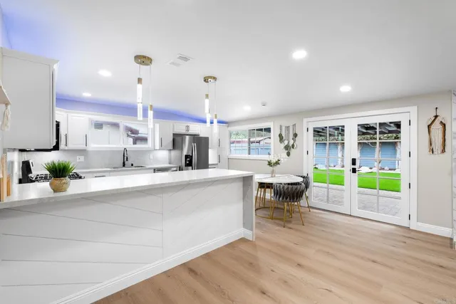 a kitchen with a table chairs refrigerator and cabinets