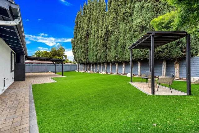a view of house with backyard and a slide