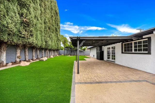a view of a house with backyard and a tree