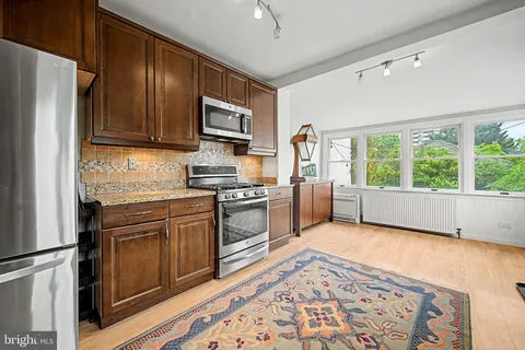 a kitchen with stainless steel appliances granite countertop a refrigerator stove top oven and sink