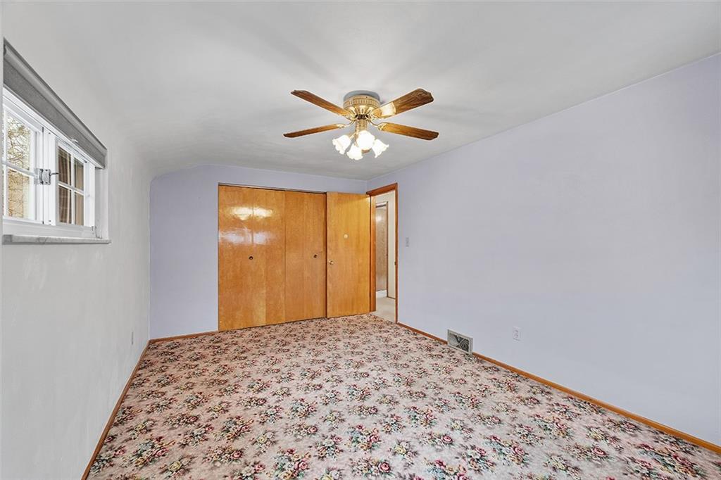 515 Braddock Road Pittsburgh, PA 15221 - Photo 20 of 38 a bedroom with a bed and a chandelier