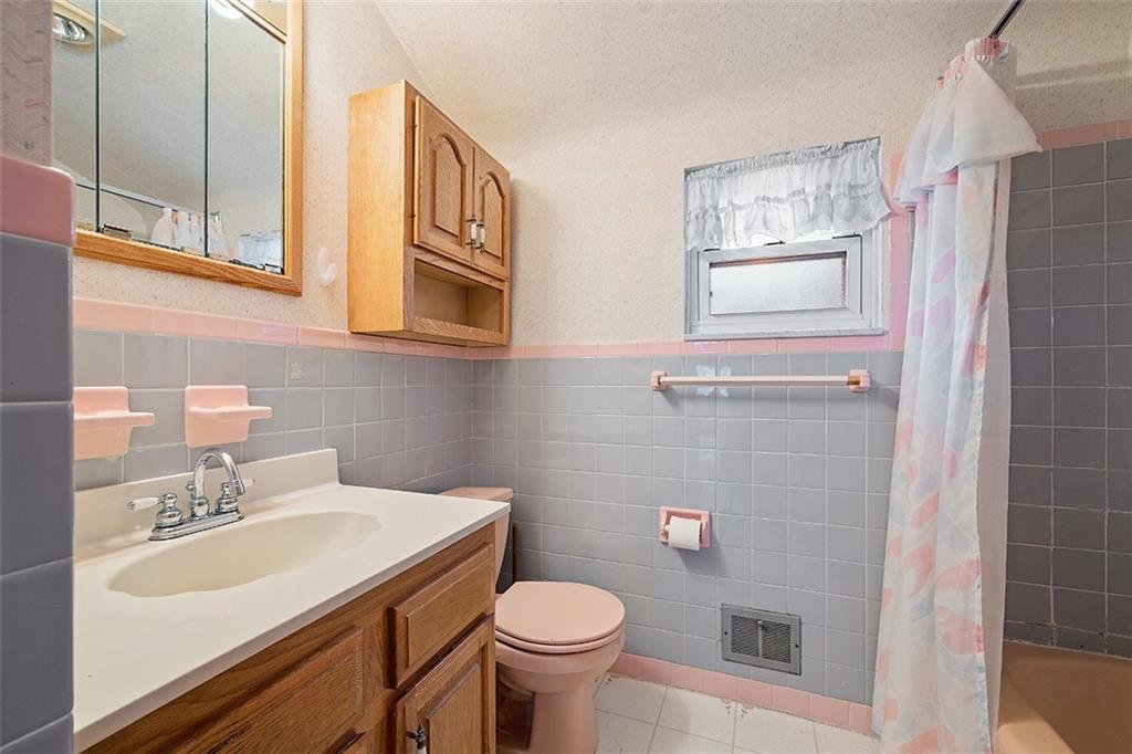 515 Braddock Road Pittsburgh, PA 15221 - Photo 24 of 38 a bathroom with a sink a toilet and mirror