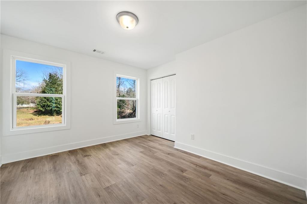 518 Old Canton Road Ball Ground, GA 30107 - Photo 20 of 42 an empty room with wooden floor and window