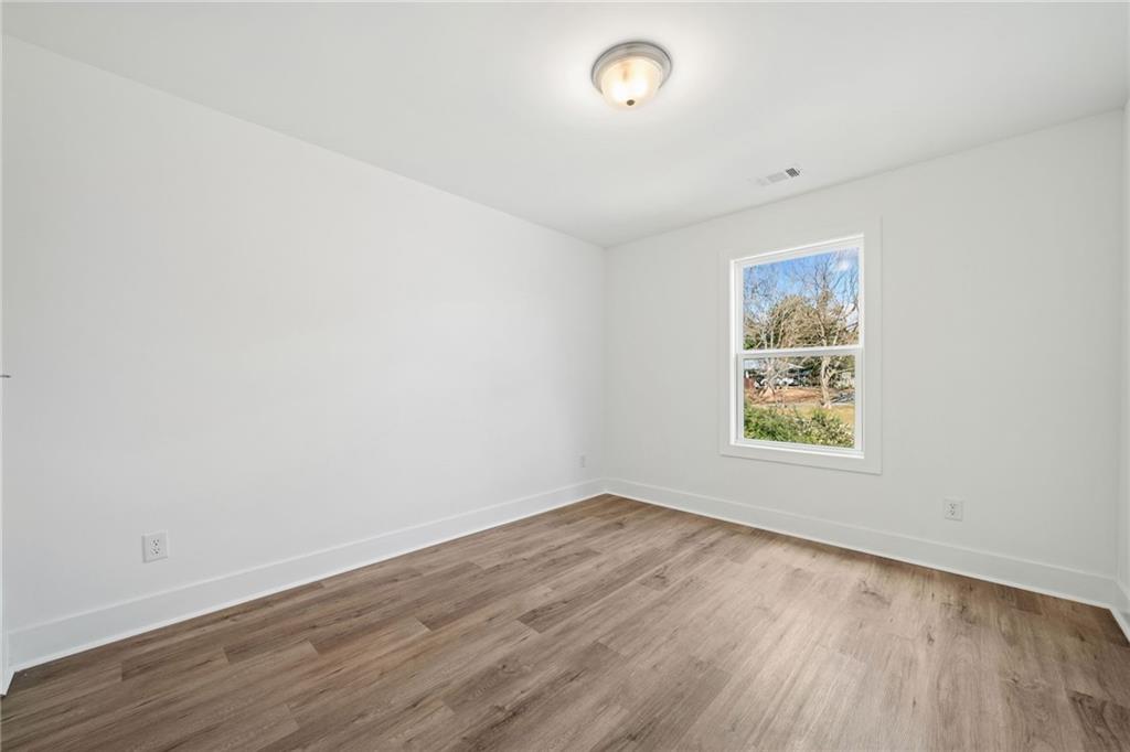 518 Old Canton Road Ball Ground, GA 30107 - Photo 21 of 42 an empty room with wooden floor and windows