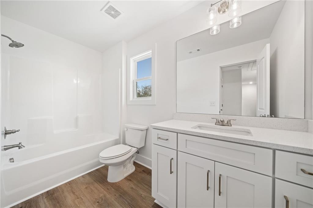518 Old Canton Road Ball Ground, GA 30107 - Photo 22 of 42 a bathroom with a double vanity sink toilet mirror and bathtub