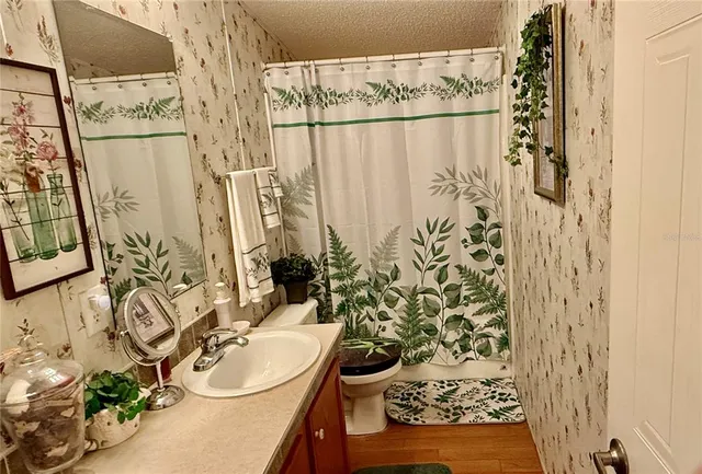 a living room with furniture a flat screen tv and floor to ceiling window