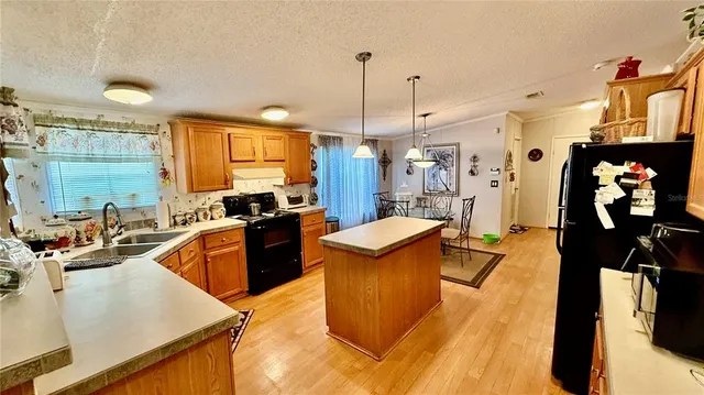 a kitchen with stainless steel appliances granite countertop sink stove and refrigerator