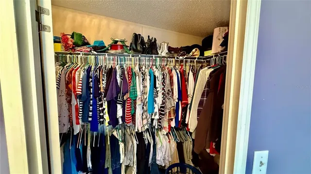a view of walk in closet with clothes