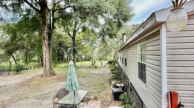 a backyard of a house with table and chairs
