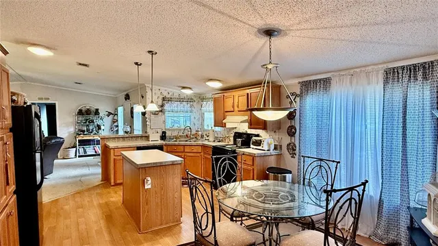 a room with stainless steel appliances kitchen island granite countertop furniture and a wooden floor