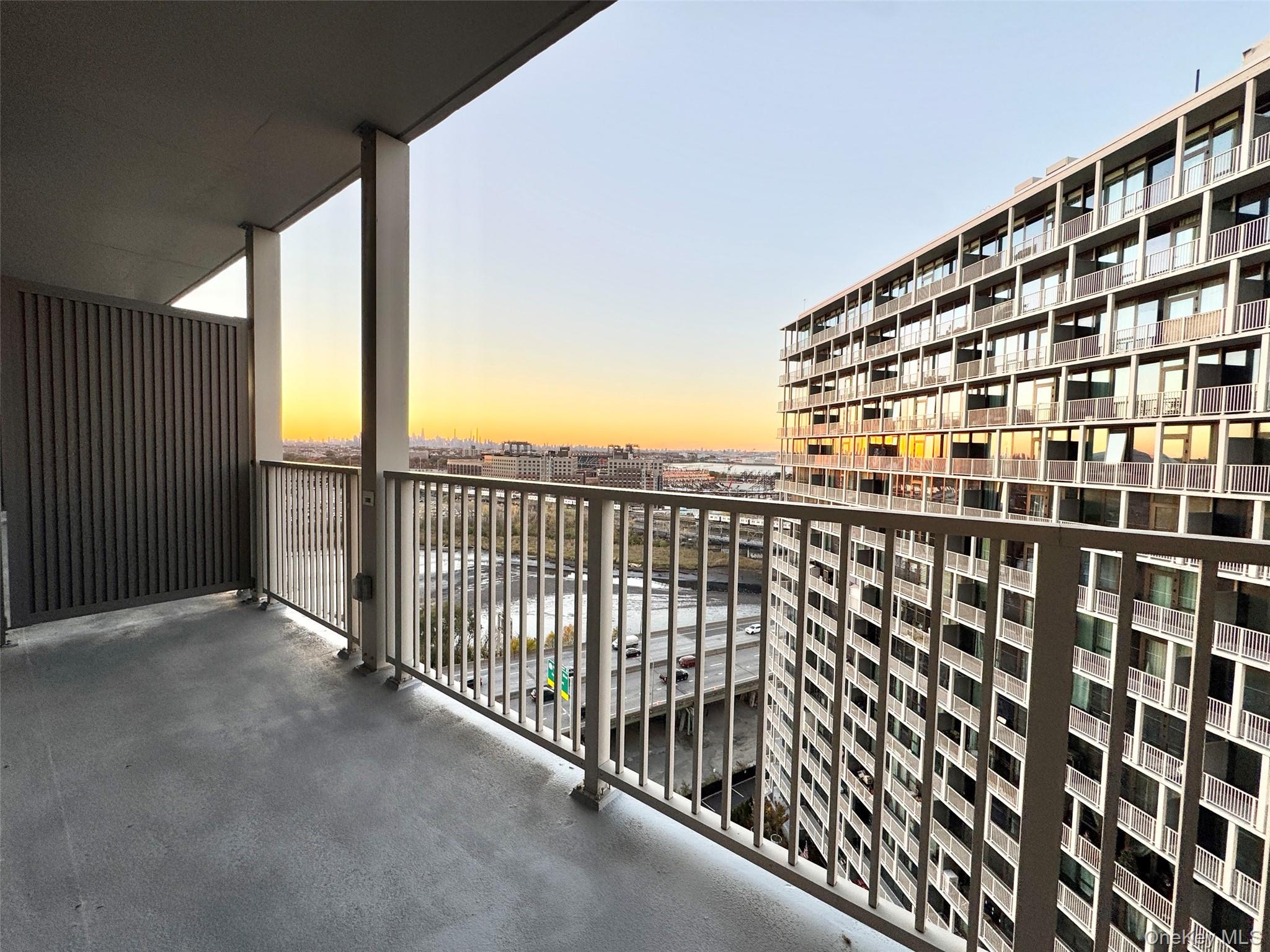131-02 B 40th Road, Unit 16M Queens, NY 11354 - Photo 12 of 17 a view of balcony with a floor to ceiling window and wooden fence