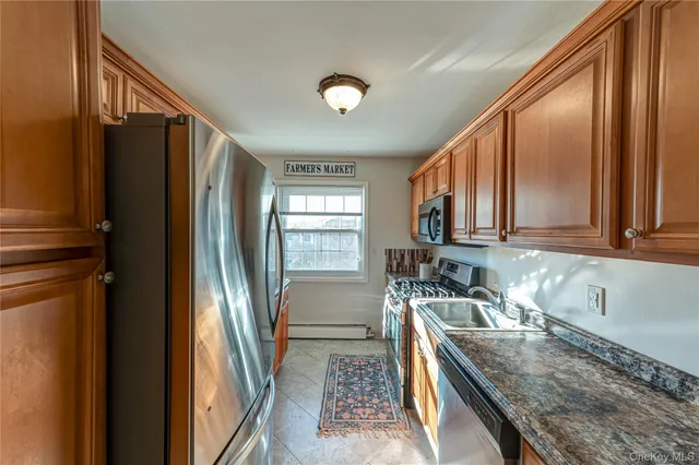 a kitchen with granite countertop a refrigerator a sink and dishwasher